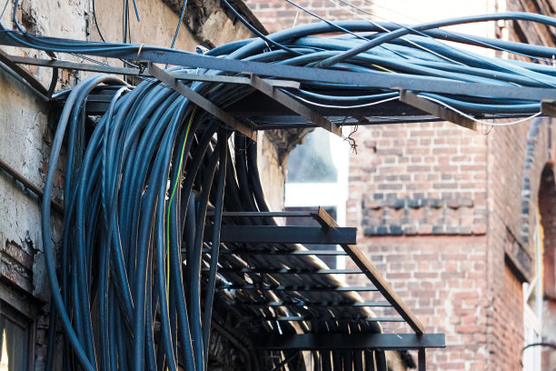 工厂墙壁上的电缆堆，为生产提供电力图片下载