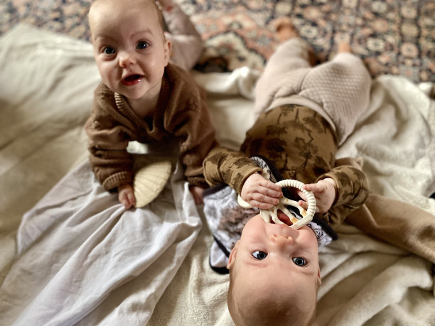 可爱的双胞胎宝宝在地板上玩耍图片下载