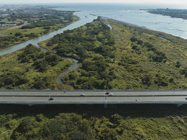 汽车在高速公路路口行驶的鸟瞰图。桥梁道路与绿色花园和树木连接的建筑概念图片下载