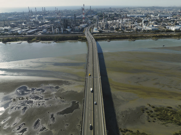 汽车在高速公路路口行驶的鸟瞰图。桥梁道路与绿色花园和树木连接的建筑概念图片下载