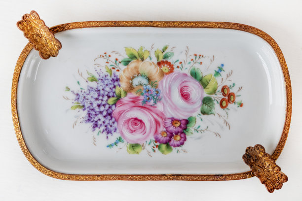 美丽的意大利瓷器盘子，白色背景上装饰着花朵和黄金。复古烟灰缸与花卉装饰。图片下载