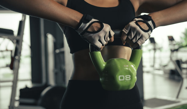 近距离的年轻女子做锻炼壶铃在健身房。图片下载