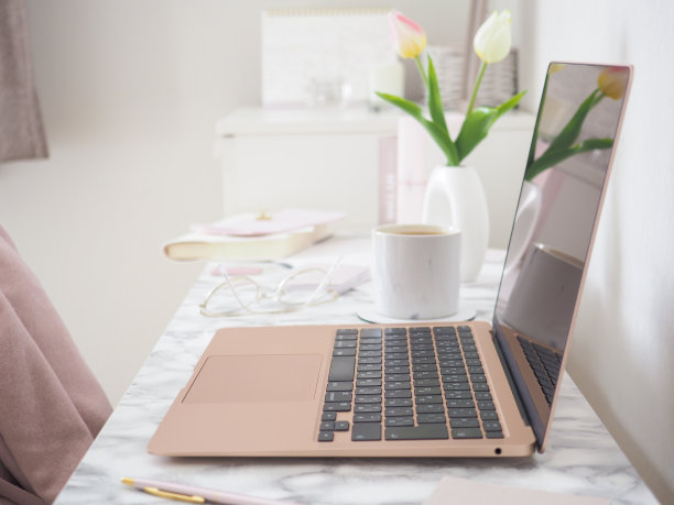 一个笔记本电脑和一个笔记本在一个时尚的工作空间图片下载