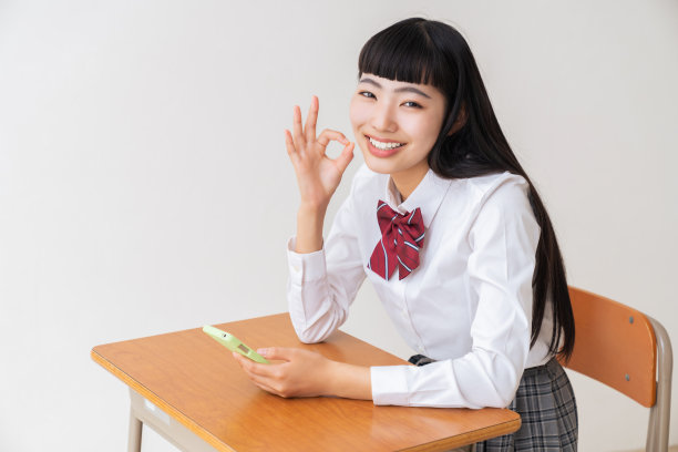 女学生使用智能手机，学校教室图片下载