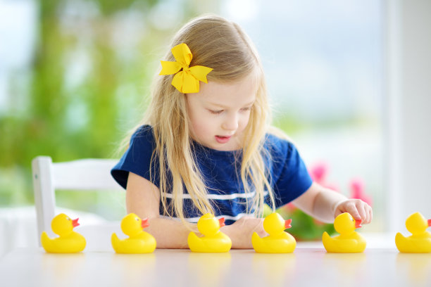 可爱的小女孩在家里玩橡皮小鸭图片下载