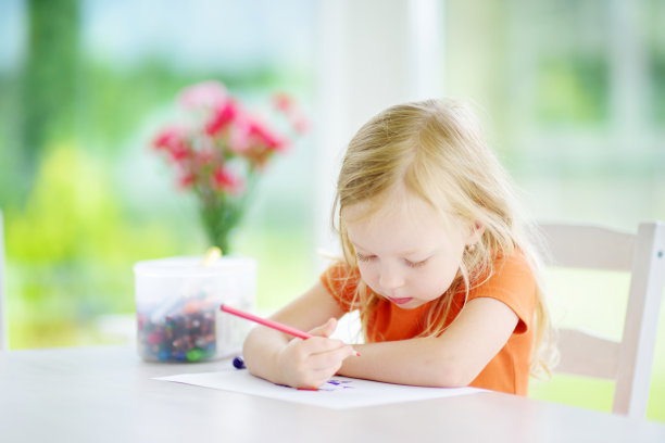 可爱的小女孩在日托所用铅笔画画。有创造力的孩子在学校画画。女孩在家里做作业。图片下载