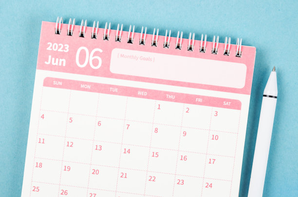 2023年6月日历桌，蓝色背景上有笔供组织者规划和提醒。图片下载