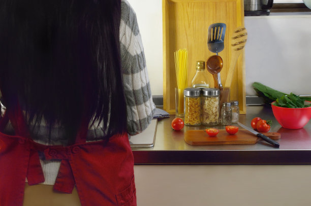 与穿红围裙的女人一起做饭的图片图片下载