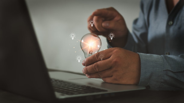 商人拿着一个明亮的灯泡。伟大的灵感和创新在新的开始创造。图片下载