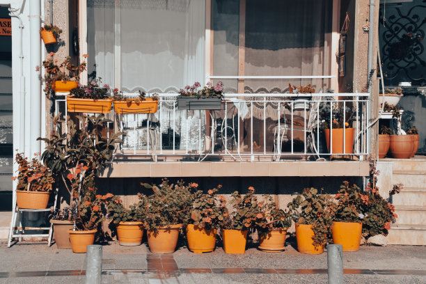 阳台的地中海，爱琴海风格的房子与彩色的花朵，橙色的花盆，椅子，桌子和窗户图片下载