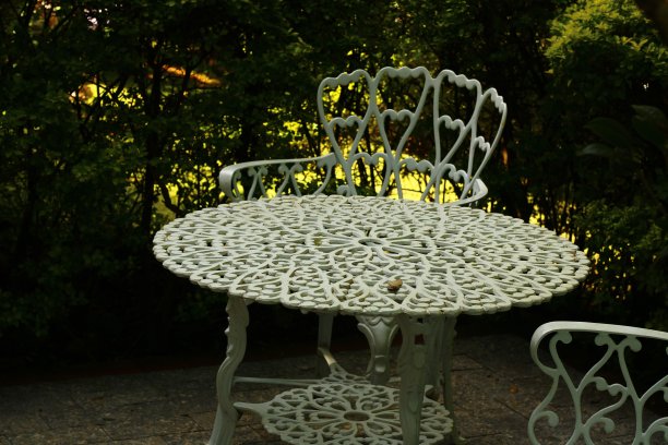 白色花园桌椅。树叶和鲜花构成了这一场景图片下载