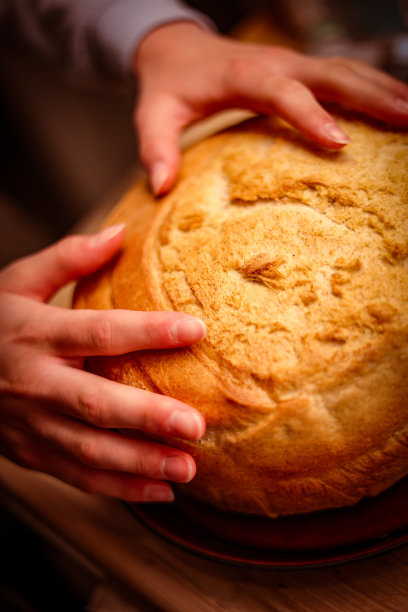 垂直拍摄手触摸新鲜出炉的面包图片下载