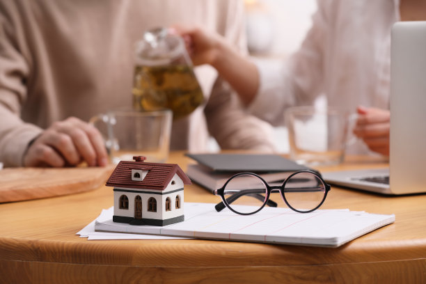 年轻夫妇在家里讨论家庭预算，重点讨论房屋模型。抵押贷款的概念图片下载