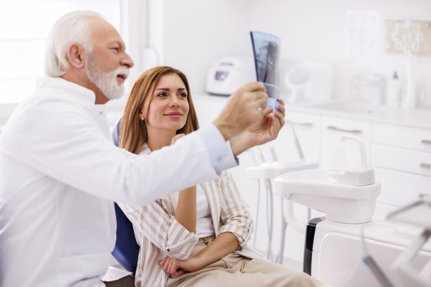 医生和病人在牙医办公室看颌x光片图片下载