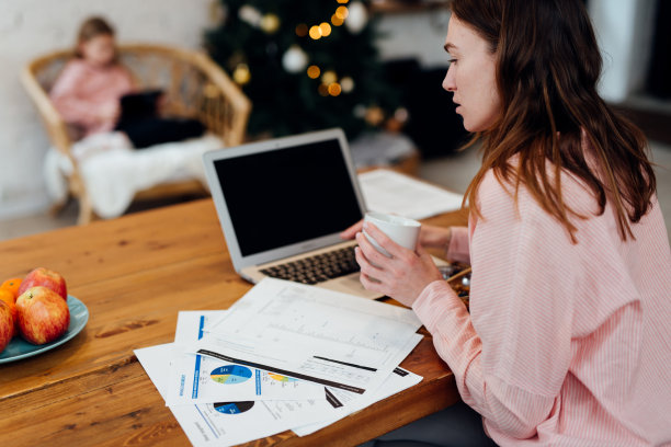 年轻的女人在寒假期间在家里的厨房工作。图片下载