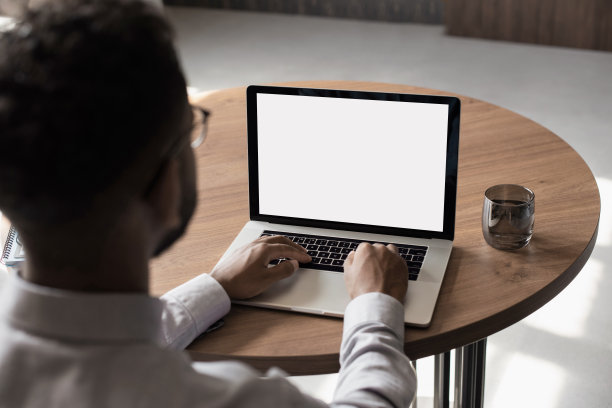 男子使用笔记本电脑与白色空白空屏幕模型图片下载