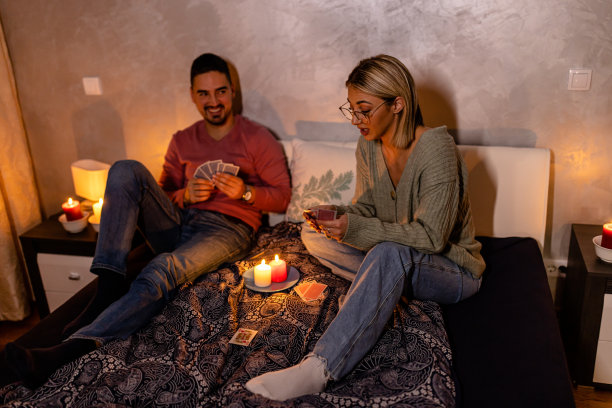 在一次电力危机中，一个年轻的男人和女人坐在家里打牌。图片下载