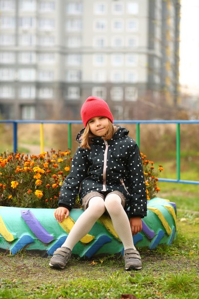 一个女孩在金盏花花坛上的秋天肖像图片下载