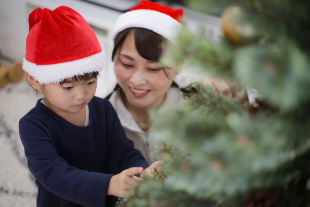 父母和孩子用圣诞树装饰图片下载