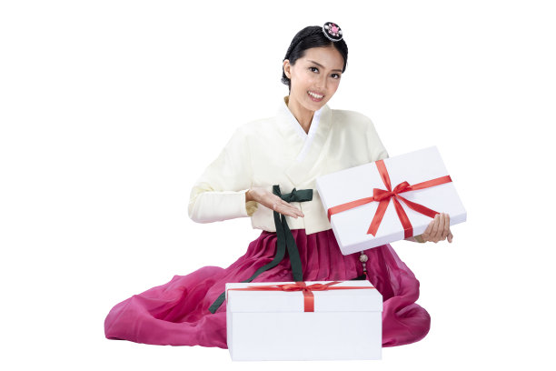 身穿韩服的亚洲妇女坐在那里，展示礼品盒图片下载
