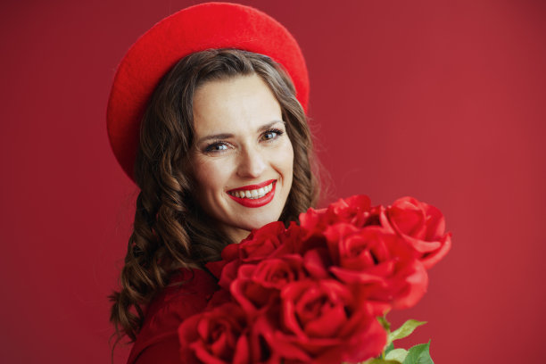 快乐的时尚女人在红色的衣服和贝雷帽的红色背景图片下载