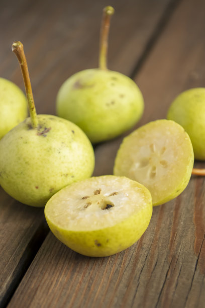 绿色的天堂苹果放在木桌上。小苹果像梨。桌上有天堂苹果。图片下载