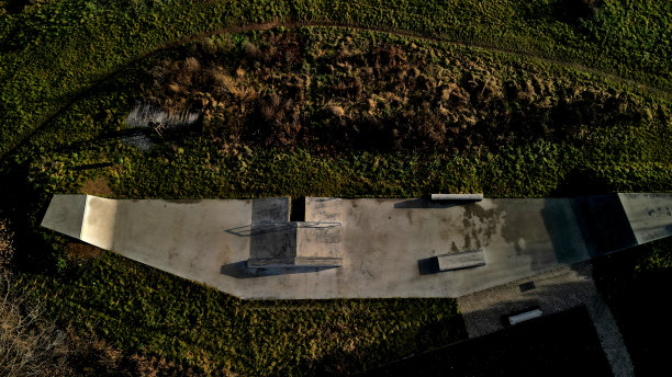 为滚轴运动设计了混凝土水泥地面滑板公园，设有混凝土滑板障碍物。除了自由式自行车外，不允许骑自行车。冬日清晨的日出，高高在上图片下载