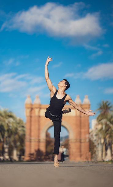 年轻男子在巴塞罗那的街道上跳着经典芭蕾，背景和灯光都很漂亮图片下载