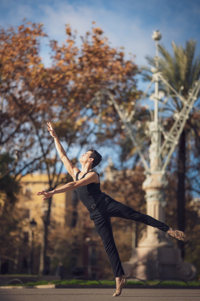 年轻男子在巴塞罗那的街道上跳着经典芭蕾，背景和灯光都很漂亮图片下载