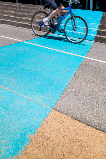 骑单车者越过蓝色路标的图像图片下载