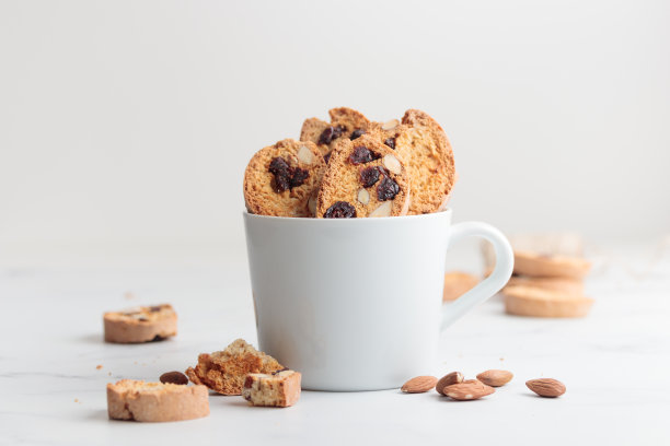 白色杯装脆饼，白色底配杏仁和蔓越莓图片下载