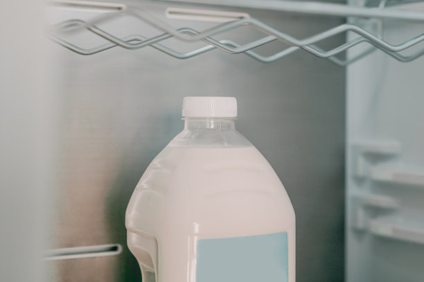 冰箱里孤零零地放着一个蓝色空白标签的塑料瓶牛奶。模型。实物模型。冰箱。饮料。液体。存储图片下载