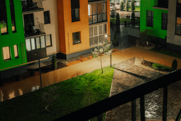 五颜六色的新住宅庭院，雨天的黄色路面。下雨了。天井。现代建筑。城市。的城市。舒适。晚上。的夜晚。潮湿的人行道。绿色的草。降水图片下载