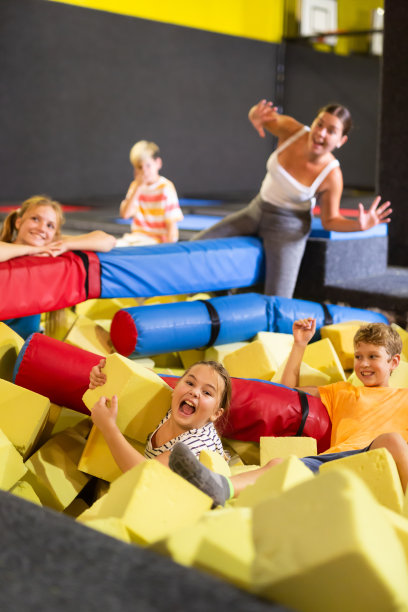 在室内儿童娱乐中心，顽皮快乐的孩子们聚在一起玩泡沫方块，互相投掷图片下载