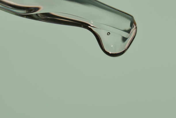 近距离移液管滴一滴天然有机精华液用于面部或精华有机油用于年轻化。在一个时尚的浅绿色背景。高质量照片图片下载