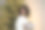 一名非裔美国妇女在房子舒适的客厅的圣诞树旁拿着一份节日礼物图片下载