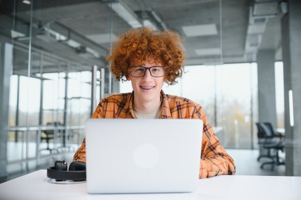 男程序员通过笔记本电脑自由工作时戴眼镜保护眼睛，聪明的学生在上网本上看教程。图片下载