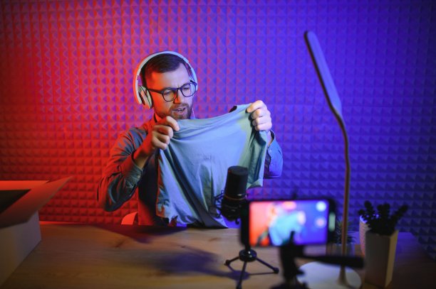 时尚博主录制视频内容，在家开箱新毛衣。千禧一代网红在专业摄像机前用新衣服开箱，社交媒体直播。图片下载