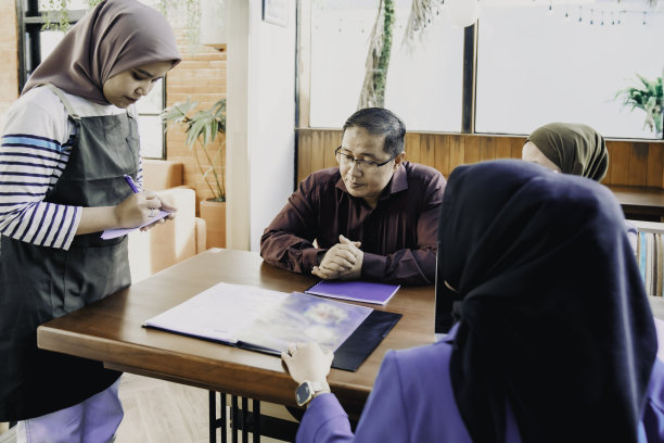 漂亮的女服务员在咖啡馆从顾客点菜图片下载