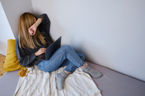 一个小女孩在笔记本电脑前睡着了。漂亮女人累了或者工作过度了。舒适的家居环境图片下载