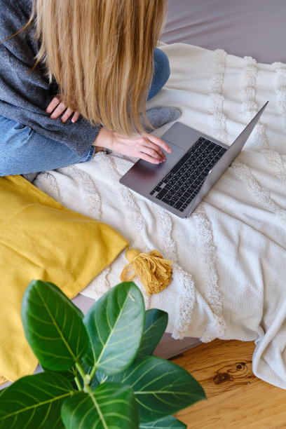 一个女人在笔记本电脑后面工作。互联网业务。自由的女孩。远程工作。现代生活方式，工作日。移动设备。在键盘上打字图片下载