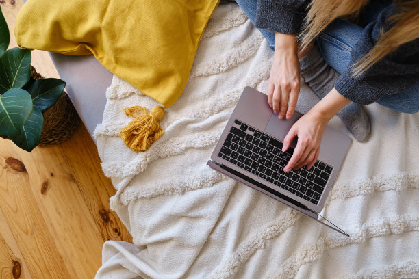 一个女人在笔记本电脑后面工作。互联网业务。自由的女孩。远程工作。现代生活方式，工作日。移动设备。在键盘上打字图片下载