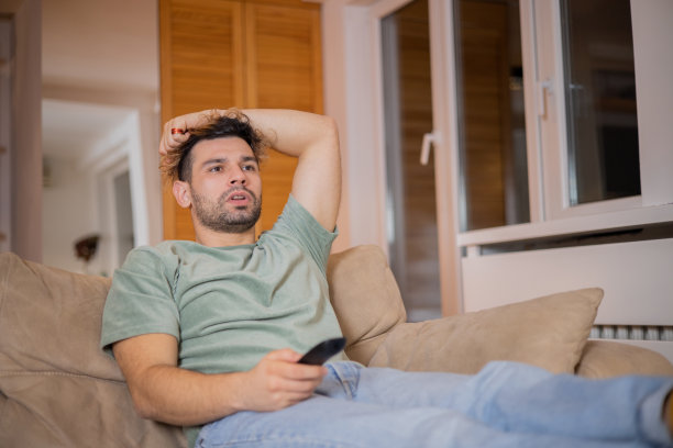 男人在家里享受他最喜欢的电视节目图片下载