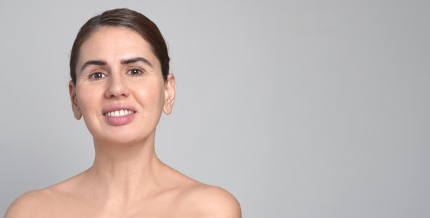 中年妇女白色背景。40岁的女性微笑着看着镜头。享受她的自然美，高自尊，健康的概念。天然美容护肤品。聚焦放大肖像与孤立的背景图片下载