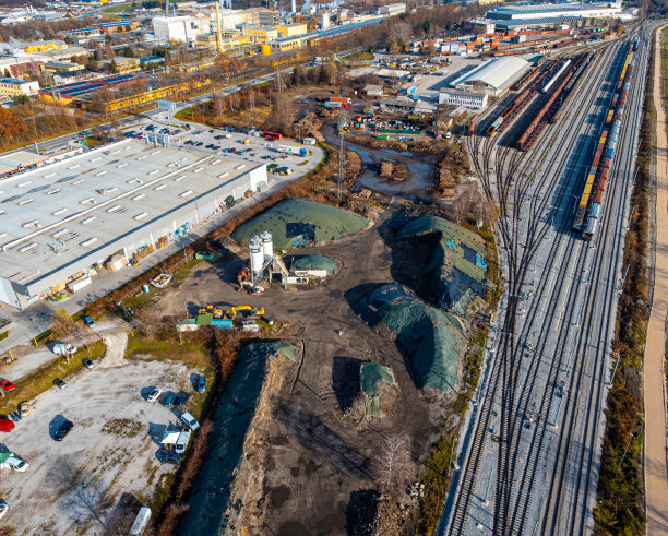 鸟瞰铁路仓库的散装货物，砾石，沙子，与仓库和城市天际线的背景图片下载