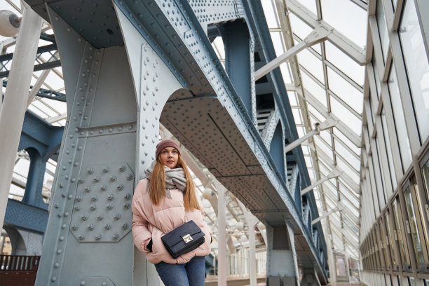 一个美丽的年轻女子在一座由玻璃和金属建造的现代建筑里图片下载