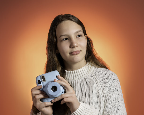一个十几岁的女孩用宝丽来相机拍照图片下载