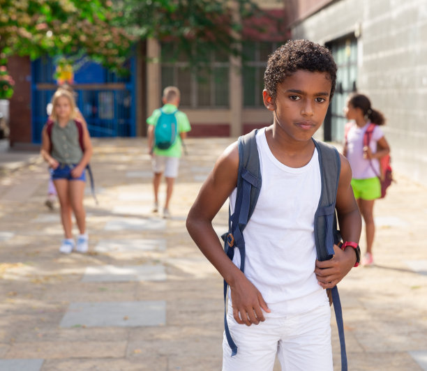 一个非裔美国男孩在放学后走在校园里图片下载