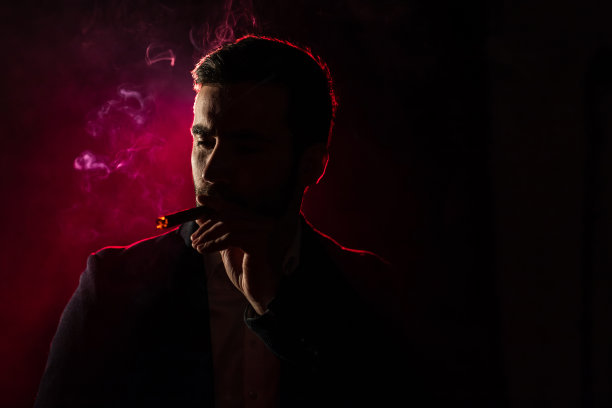 粉红色背景上吸烟男子的照片。图片下载