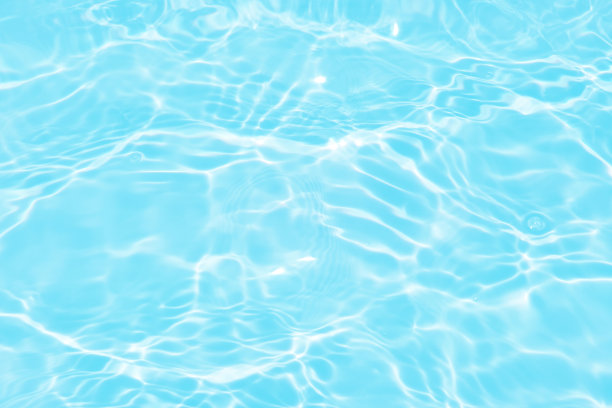 离焦模糊透明蓝色颜色清晰平静的水面纹理与飞溅和气泡。潮流抽象的自然背景。水波在阳光下带有焦散。碧水浪花闪闪发光图片下载